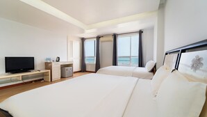 A hotel room with a bed, a TV, a desk, and a window with curtains. - Palette Muine Boutique Hotel Near Mui Ne Beach (1 Bao Loc)