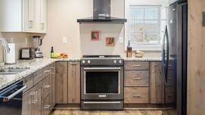 A kitchen with a built-in oven, a stove, a sink, and a refrigerator.