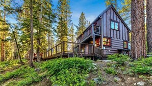 A cabin with a wooden exterior, a balcony, and a staircase leading to the entrance. - Creekside Old Tahoe style meets modern cozy Zen Den (Tahoe City)