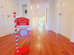 Un pasillo con un poste a rayas rojas y blancas que dice 'North Pole Express Post' y un letrero que dice 'Cartas a Santa'.