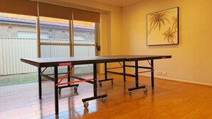 Um quarto com uma mesa grande, uma porta de correr de vidro e um quadro pendurado na parede.