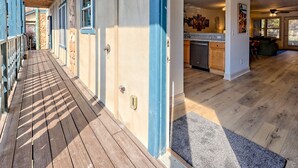 A covered wooden deck leading to a house with a stone facade and blue trim. - Heart of Helen - 1st Floor | Walk to Main Square (Helen)
