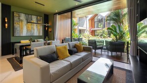 Uma sala de estar moderna com sofá, mesa de centro e área de jantar.