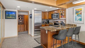 A modern kitchen with wooden cabinets, stainless steel appliances, and a granite countertop. - Stonebridge Condos 1 Bdrm, Direct ski-in/ski-out (Snowmass Village)