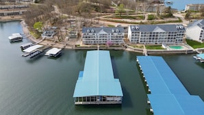 Um hotel à beira-mar com vários edifícios, um cais com barcos e uma grande área de piscina.