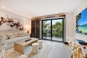 A modern living room with a sofa, coffee table, and a painting. - Bali Hai Beach Resort (Holmes Beach)