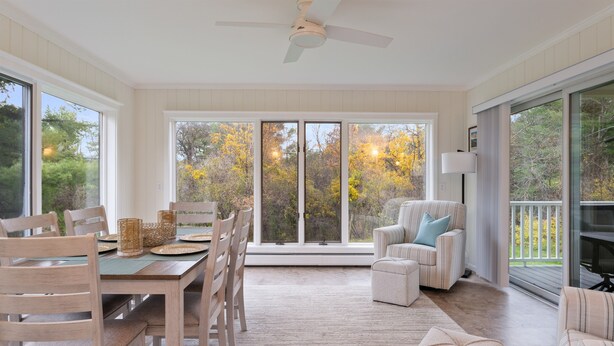 A spacious room with a dining area, a sofa, and a large sliding glass door leading to a balcony. - 3 Mins to Watkins Glen | Seneca Wine Trail (Watkins Glen)