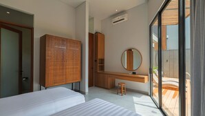 Egy modern hálószoba két ággyal, egy fa szekrénnyel, egy tükörrel ellátott íróasztallal és kilátással a balkonra.