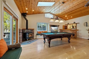 Ein gemütliches Wohnzimmer mit Billardtisch, Kamin und Poolbillard.