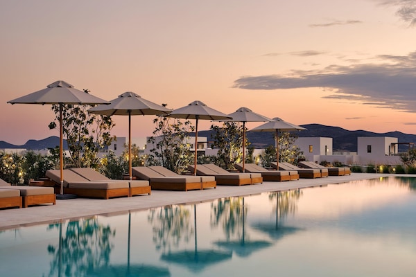 Una piscina al aire libre de temporada, sombrillas