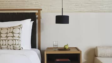 A neatly arranged bedroom with a bed, bedside table, and a small nightstand.