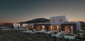 Una casa moderna de varios pisos con piscina, detalles de piedra y vistas del paisaje circundante.