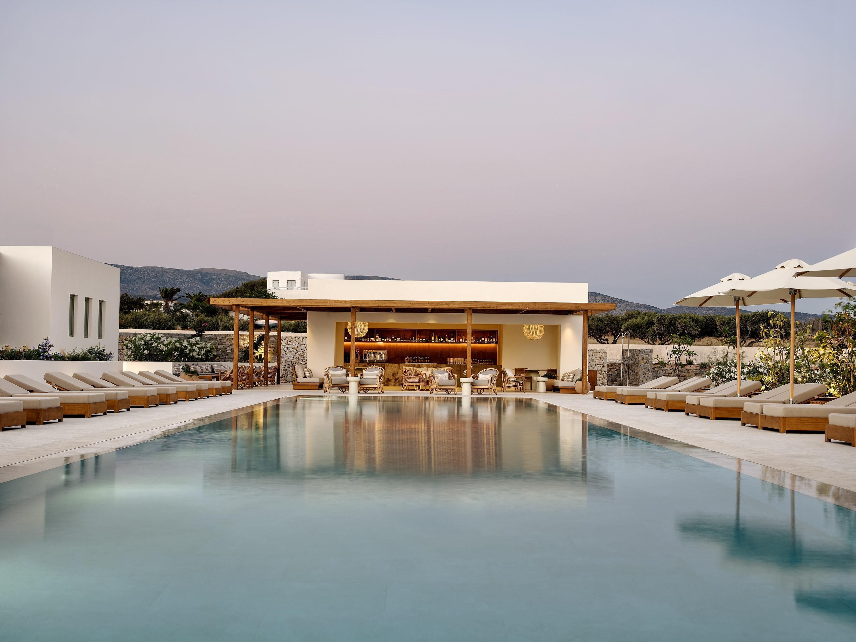 Una piscina al aire libre de temporada, sombrillas