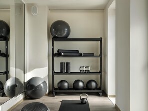 A gym with exercise equipment, a mirrored wall, and a wooden floor. - Parian Chronicle Hotel Paros, Destination by Hyatt (Paros)