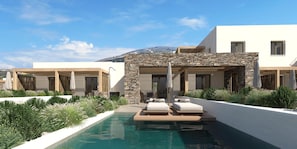 Un espace moderne aménagé au bord de la piscine, avec des chaises longues, un mur en pierre et une vue sur une montagne.