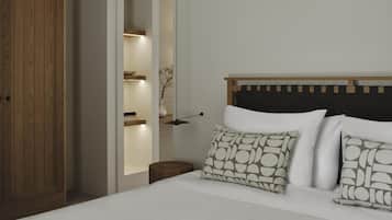 Un dormitorio con un armario de madera, una mesita de noche, una cama con ropa de cama blanca y un cabecero con estampado geométrico.