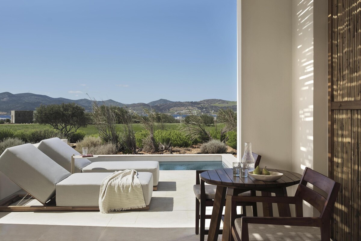 Eine Terrasse mit Pool, Liegestühlen und einem Tisch mit Stühlen.