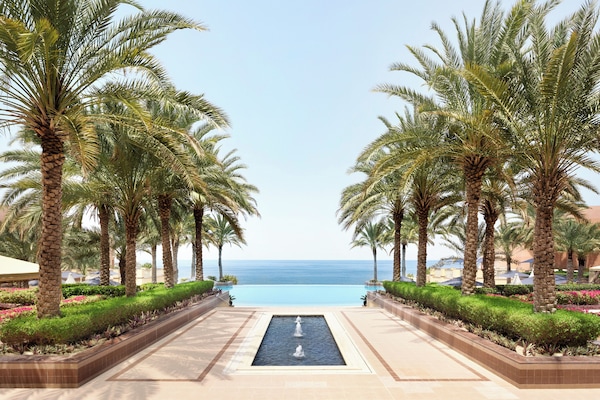 Alberca al aire libre, sombrillas en la alberca y camastros