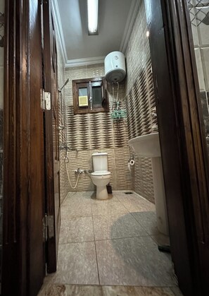 Un baño con inodoro, lavamanos y ducha.