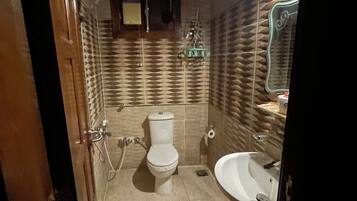 Un baño con inodoro, lavamanos y espejo.