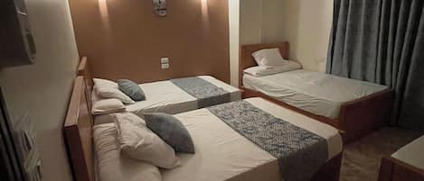 Una habitación de hotel con dos camas individuales, un ventilador de techo y lámparas de noche.