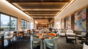 A spacious lobby with a high ceiling, large windows, and a coffee bar. - Novotel Kunming Yunjin (Kunming)