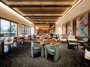 A spacious lobby with a high ceiling, large windows, and a coffee bar. - Novotel Kunming Yunjin (Kunming)