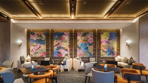 A modern conference room with a central table, surrounded by chairs, and large abstract wall art. - Novotel Kunming Yunjin (Kunming)