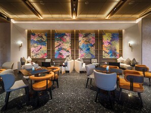 A modern conference room with a central table, surrounded by chairs, and large abstract wall art. - Novotel Kunming Yunjin (Kunming)