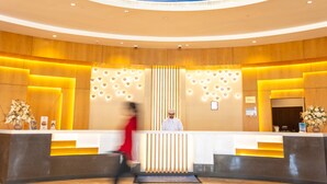 A hotel lobby with a central reception desk, a decorative ceiling mural, and a polished floor. - Tulip Inn Majan Hotel (Salalah)
