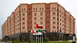 A large, multi-story hotel with a symmetrical facade, multiple windows, and a central entrance. - Tulip Inn Majan Hotel (Salalah)