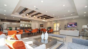 Eine großzügige Hotelhalle mit modernem Design, inklusive einer zentralen Sitzecke, einem Essbereich und einer Rezeption.