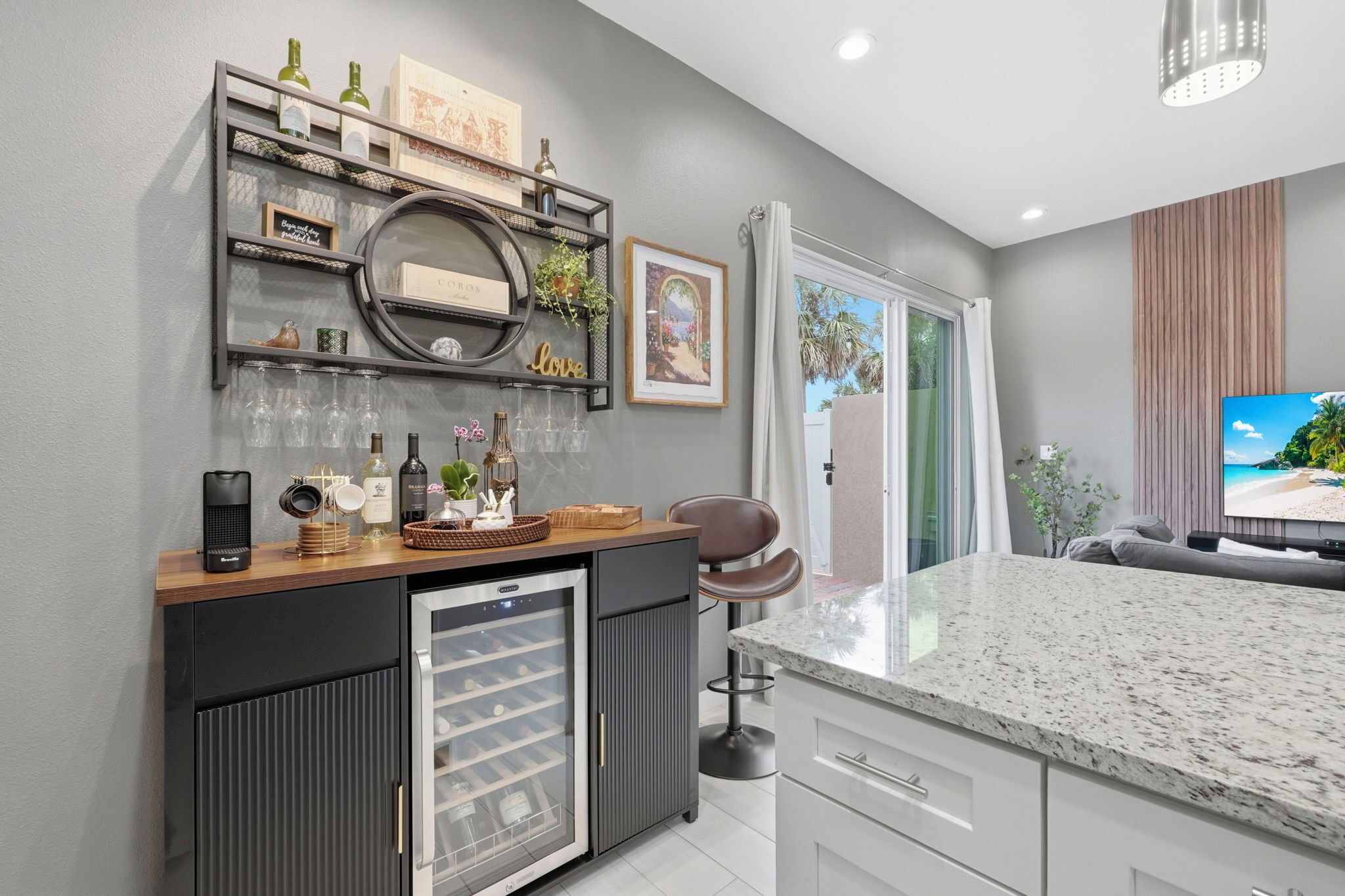 A modern kitchen with a built-in wine cooler, a wooden countertop, and a large island.