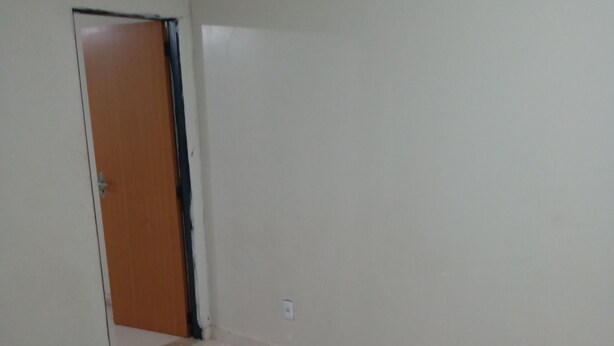 A room with a tiled floor, a wooden door, and a white wall. - M norte  (Taguatinga)