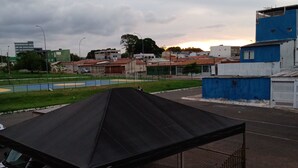 A covered outdoor area with a metal roof, a fenced enclosure, and a staircase leading down. - M norte  (Taguatinga)