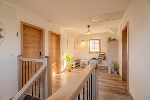 A hallway with wooden doors, a staircase, and a bench. - Lukec Homestead Adventure Studio Meta, Kostel, Slovenia (Kostel)