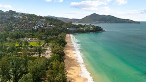 A coastal area with a beach, houses, and a mountain in the background. - Surin 2BR Resort Condo With Seaview@chava (Choeng Thale)