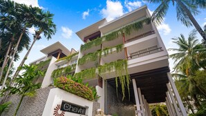 A modern hotel with a white facade, multiple balconies with hanging plants, and a sign reading "The Chava". - Surin 2BR Resort Condo With Seaview@chava (Choeng Thale)
