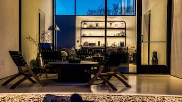An interior space with a round table, two chairs, a plant, and a fireplace.