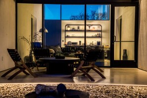 An interior space with a round table, two chairs, a plant, and a fireplace. - 8 mins from Round Top Luxury Casita overlooking breathtaking views! (Burton)