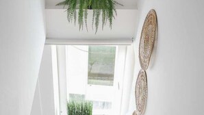 Una escalera moderna con escalones de madera que conduce a un rellano con un ventanal.