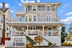A two-story house with a balcony on the upper floor and a front porch.