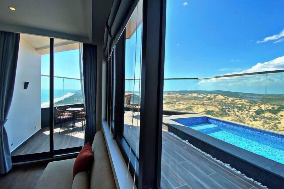 A modern room with a large window overlooking a pool and a scenic view.