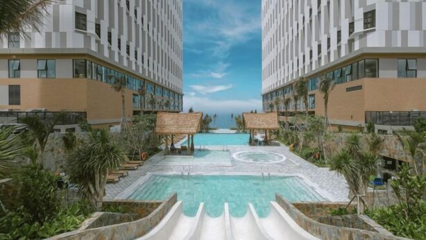 Un complexe hôtelier doté d’une piscine centrale, de deux immeubles imposants et d’un toboggan aquatique.