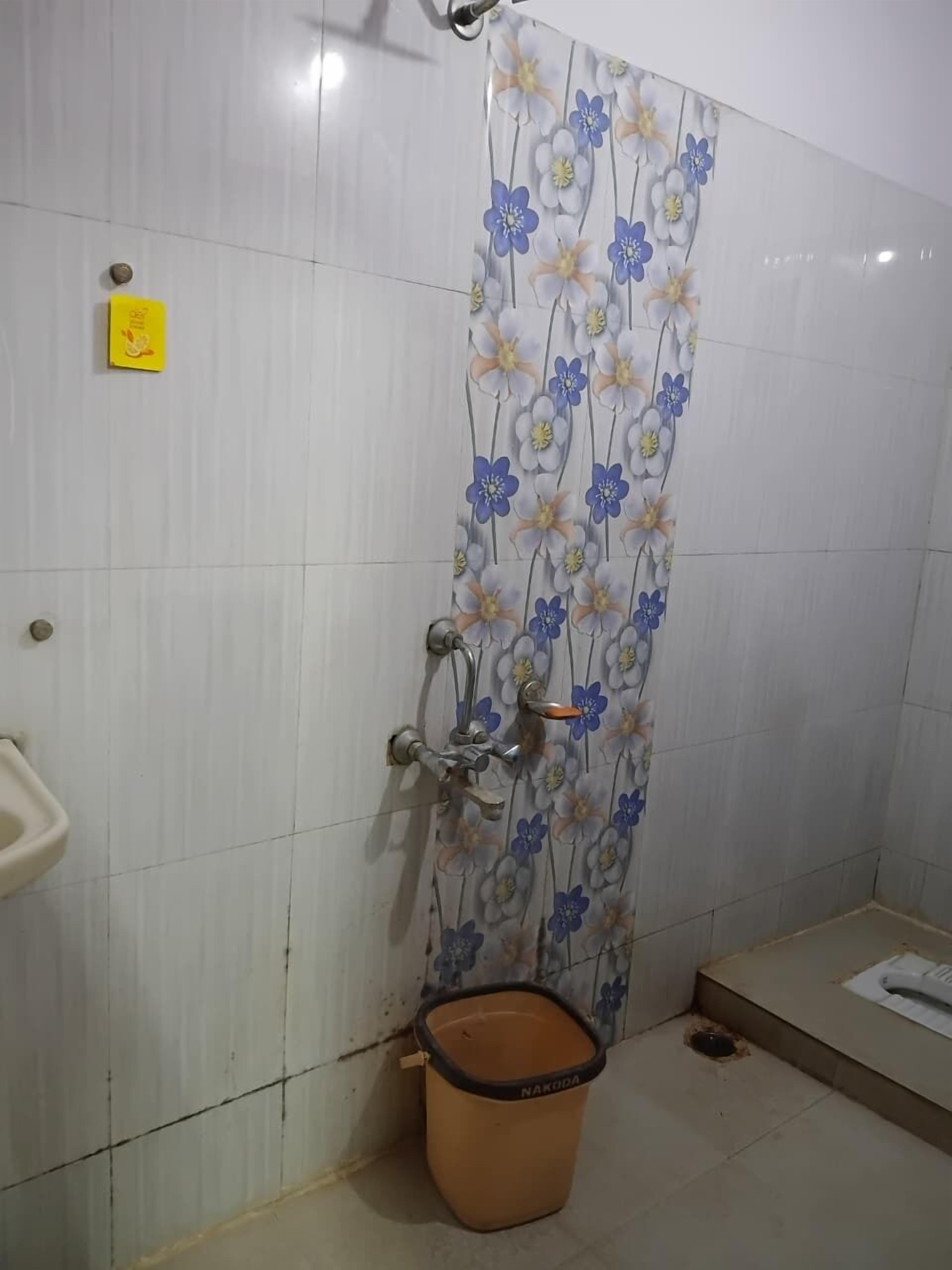A bathroom with a shower curtain featuring a floral pattern, a toilet, and a sink.