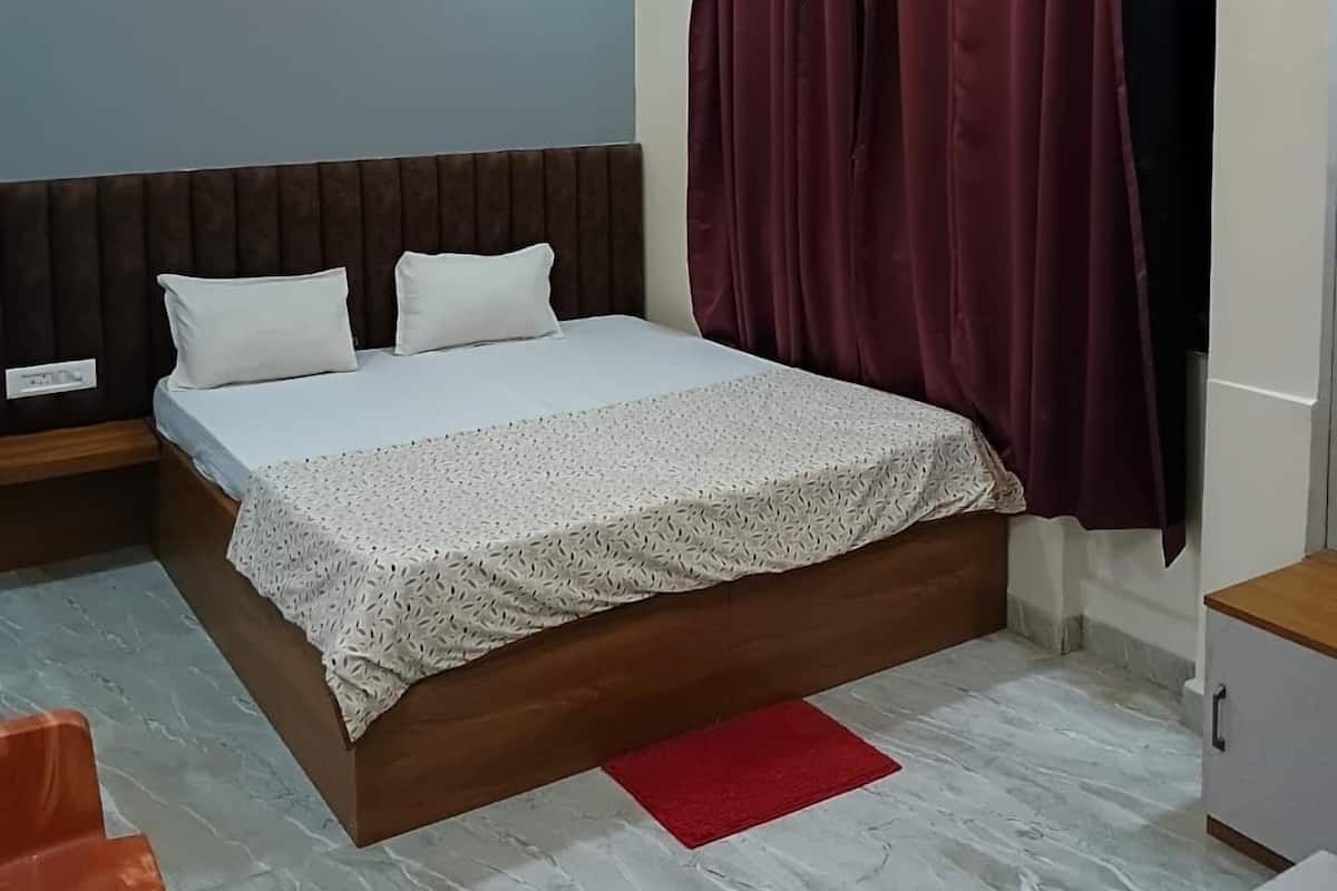 A modern bedroom with a bed, a nightstand, a red rug, and a ceiling fan.
