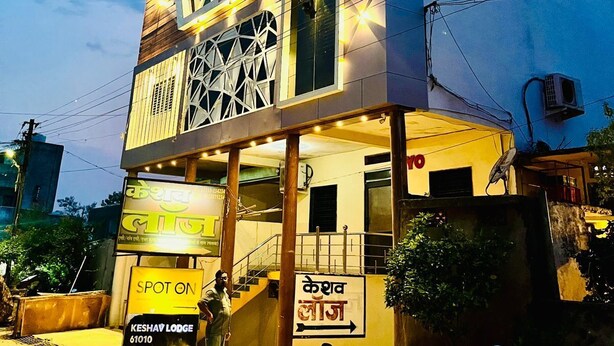A hotel with a modern facade, a prominent 'Hotel' sign, and a 'Spot on' sign indicating a nearby location. - Hotel Keshav (Savner)