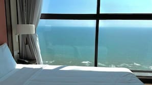 A hotel room with a large window, a bed, and curtains. - Couple & Co. Boutique Mandala (Phan Thiet)