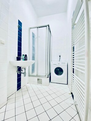 Eenvoudig appartement | Badkamer | Een douche, gratis toiletartikelen, een haardroger, handdoeken
