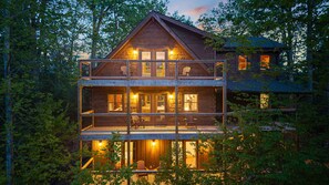 A multi-story wooden cabin with balconies, large windows, and a deck area. - The Highland • Fabulous 9BR Gatlinburg Cabin With Mountain Views (Gatlinburg)